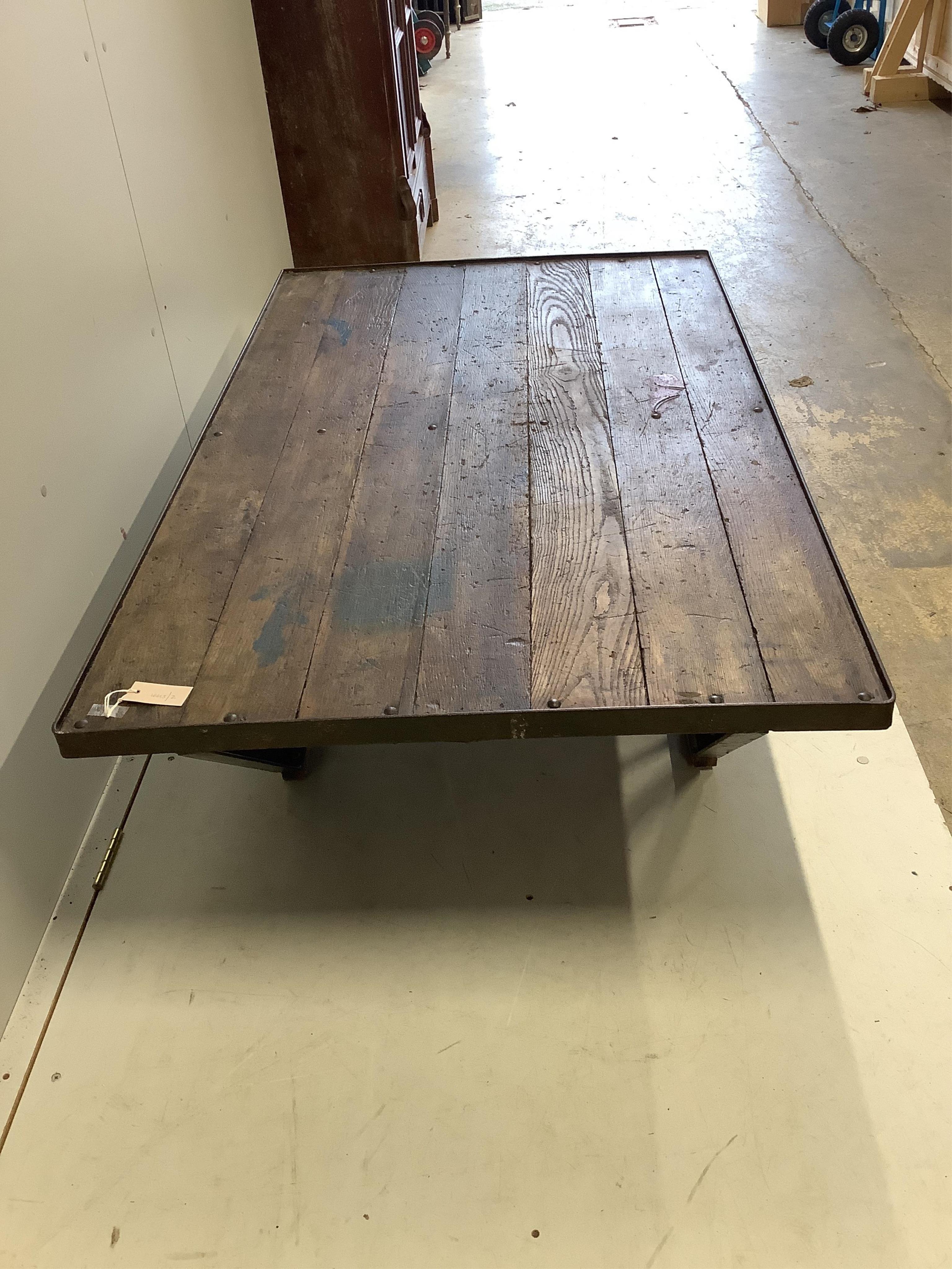 An Industrial style cast iron and planked oak coffee table converted from a Second War British military turntable, width 152cm, depth 92cm, height 38cm. Condition - good.